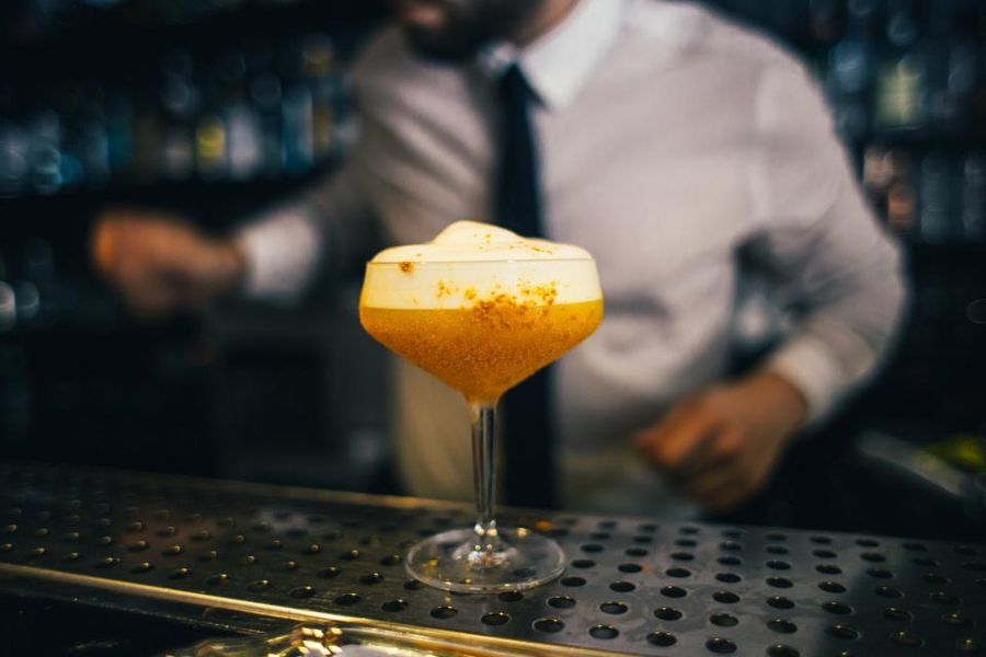 Un cocktail posé sur le comptoir, le barman derrière