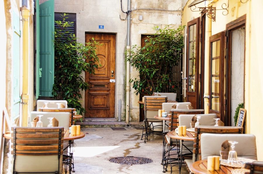 Une cour pavée avec ses tables en terrasse